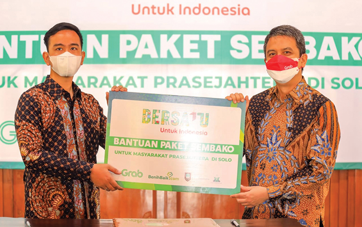 BERBAGI: Grab Indonesia beri bantuan 1.000 paket sembako pada kuli gendong dan keluarga prasejahtera di kota Solo. (SILVESTER KURNIAWAN/RADAR SOLO)