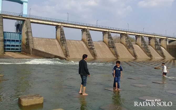 SUMBER IRIGASI: Warga bermain di kawasan Dam Colo. Seiring meningkatnya curah hujan, BPBD dan BBWSBS waspadai banjir.