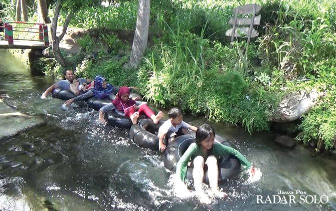 MURAH MERIAH: Wisatawan dari luar daerah merasakan sensasi tubing di aliran irigasi Desa Nepen, Kecamatan Teras, Boyolali, kemarin (1/1).