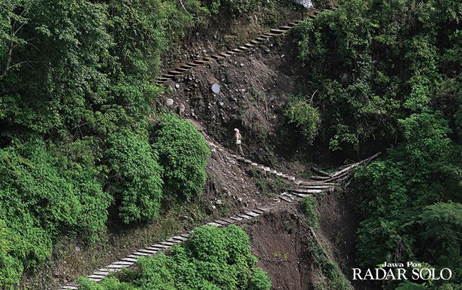 Petugas kesehatan hewan ini terpaksa naik jembatan seling yang sebenarnya untuk angkutan barang untuk mempersingkat menuju Dusun Girpasang di lereng Merapi, Jumat (3/1)