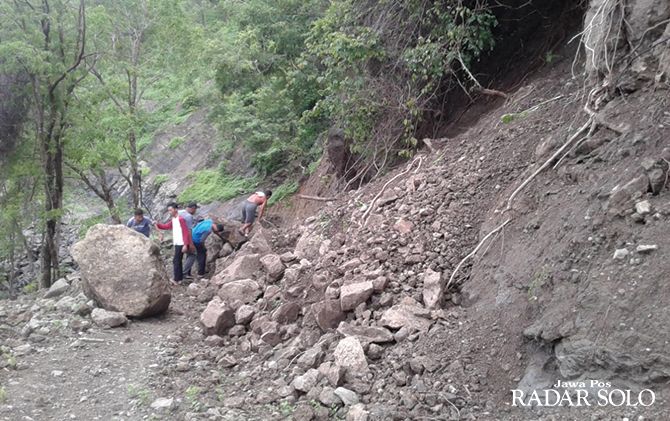 AKSES PENTING: Warga Dusun Beran, Desa Kepatihan, Selogiri berusaha mengevakuasi material longsor di jalan tembus Selogiri-Manyaran. Hingga kemarin, akses jalur itu masih putus.