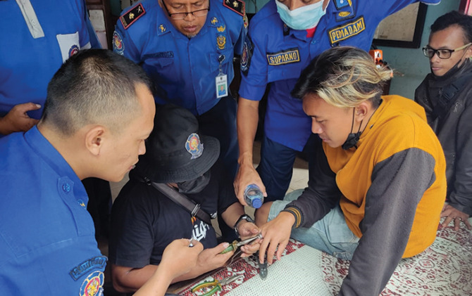 Petugas Damkar Wonogiri berupaya melepas cincin di jari Kelik Tri Nugroho, Rabu (27/10). (IWAN ADI L/RADAR SOLO)