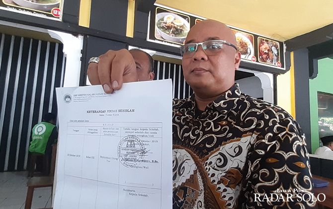 Zainal Arifin, kuasa hukum orangtua Y menunjukkan surat keterangan pindah sekolah.