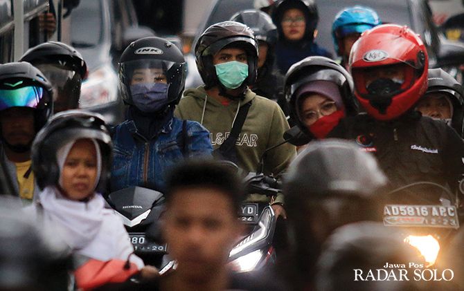 SUSAH DICARI: Sejumlah pengendara sepeda motor menggunakan masker terjebak macet di Underpass Makamhaji, Kartasura, Sukoharjo, kemarin (12/2).