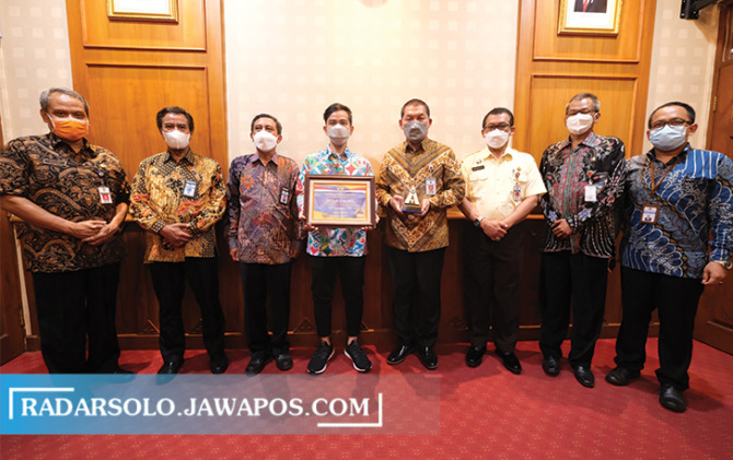 PROFESIONAL: Wali Kota Surakarta Gibran Rakabuming Raka tunjukkan piagam WTP di balai kota, Selasa (19/10). (SILVESTER KURNIAWAN/RADAR SOLO)