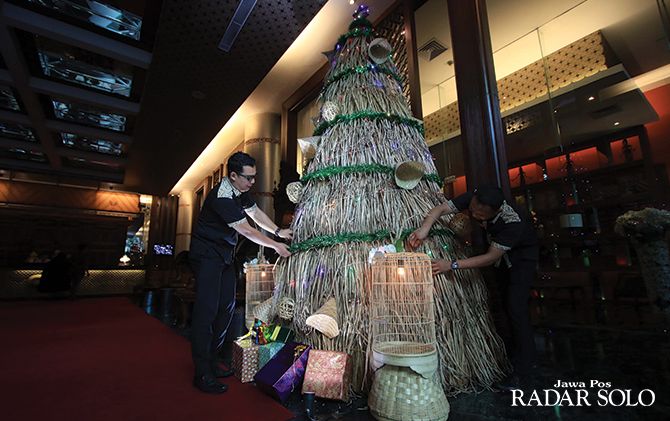 RAMAH LINGKUNGAN: Sejumlah staf The Royal Surakarta Heritage Hotel mendekorasi pohon Natal yang dibuat dari bahan dasar tanaman enceng gondok kering, Selasa (10/12).