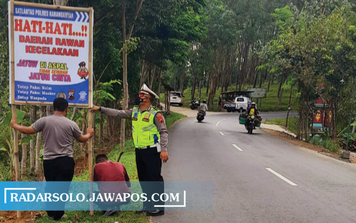 RAWAN LAKALANTAS: Kanit Laka Satlantas Polres Karanganyar Ipda Sukarno Yudo Tamtomo pasang rambu peringatan di Tohkuning, Karangpandan, Kamis (14/10). (RUDI HARTONO/RADAR SOLO)