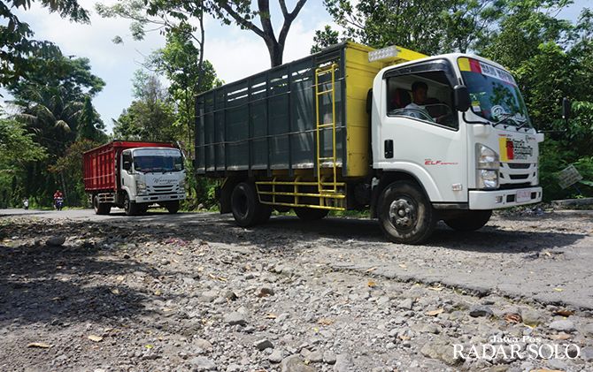 RUSAK PARAH: Dua unit truk galian C melintas di jalur evakuasi, tepatnya di Desa Tangkil, Kecamatan Kemalang, Klaten yang berlubang, kemarin (26/1).