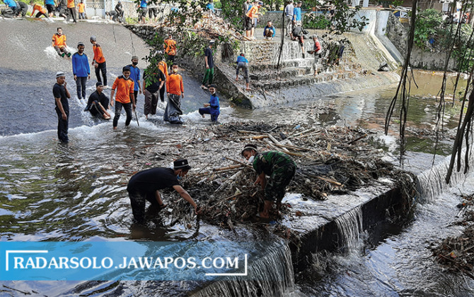PEDULI: Puluhan santri ponpes Darul Fath bersihkan sungai Sungsang, kemarin. (RAGIL LISTIYO/RADAR SOLO)