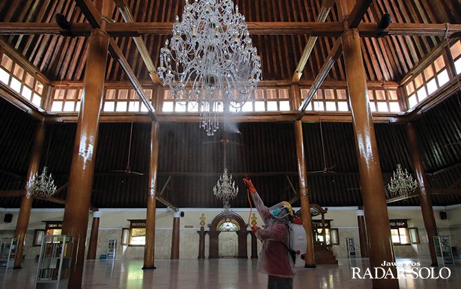 Petugas dari PMI Solo melakukan penyemprotan disinfektan di Masjid Agung Surakarta, Jumat (20/3).