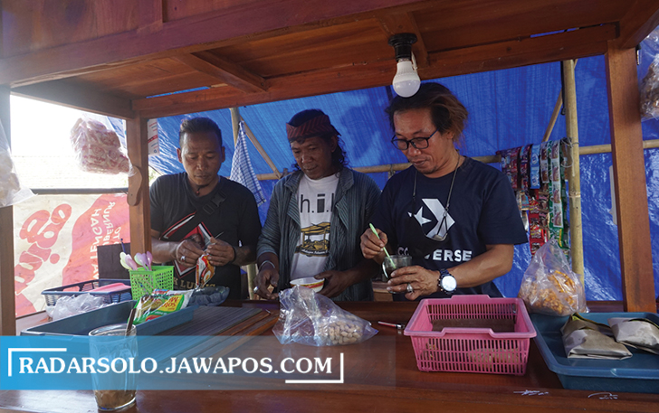 BERTAHAN: Sejumlah seniman sedang menata berbagai menu angkringan yang hendak disajikan ke pelanggan. (ANGGA PURENDA/RADAR SOLO)