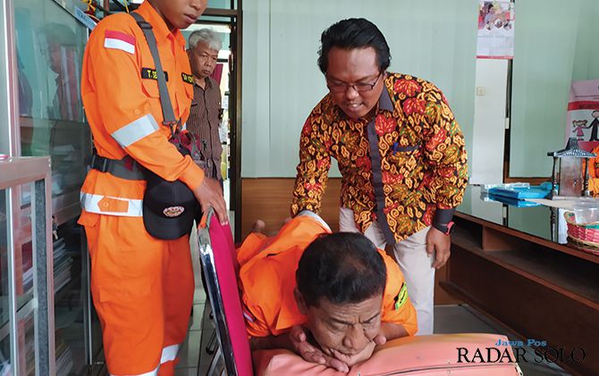 SANTAI: Fredy Sasono memijat Komandan SAR Wonogiri Warseno.