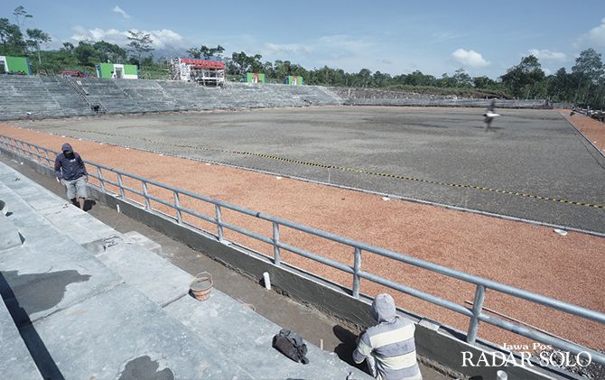 INVESTASI BIDANG OLAHRAGA: Sejumlah pekerja sedang menyelesaikan pengerjaan tribun Stadion Kebo Giro di Desa Paras, Kecamatan Cepogo, Boyolali, kemarin (18/22).