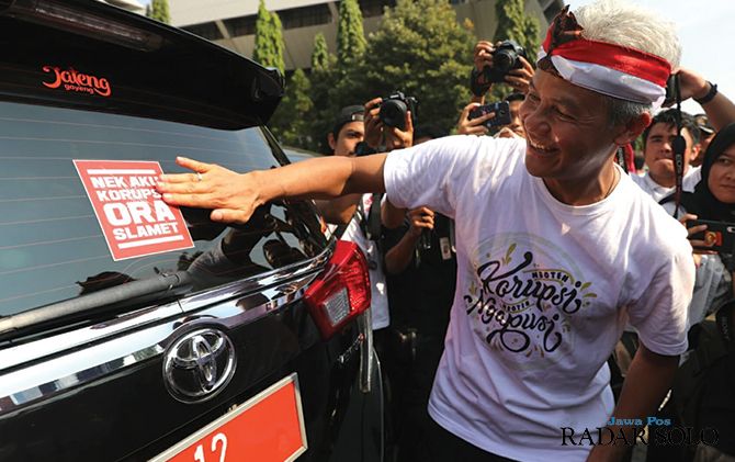 Gubernur Jateng Ganjar Pranowo memasang stiker antikorupsi di mobil dinas