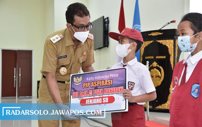 SIMBOLIS: Wakil Bupati (Wabup) Sukoharjo, Agus Santosa menyerahkan bantuan PIP kepada siswa, kemarin. (IWAN KAWUL/RADAR SOLO)