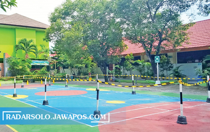 TERTATA: Halaman SD Negeri Joglo 76 diberi sekat berupa tali untuk alur penjemputan siswa, Senin (8/11). (KHOFIFAH AGNI/RADAR SOLO)