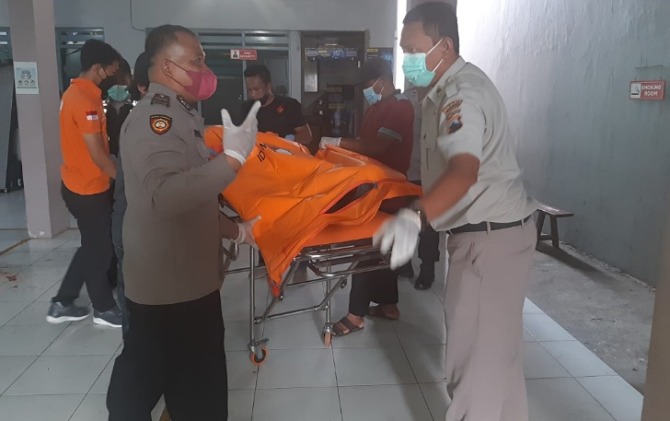 Petugas mengevakuasi jenazah korban dugaan perampokan di gudang diatribusi rokok di Serengan. (ANTONIUS C/RADAR SOLO)