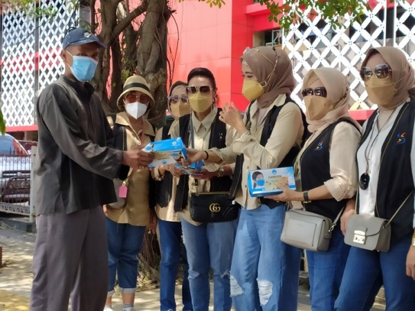 BAKTI SOSIAL: Anggota sosialita Social Community membagikan masker di kawasan Pasar Wonogiri Kota Selasa (2/11/2021). (IWAN ADI LUHUNG/RADAR SOLO)