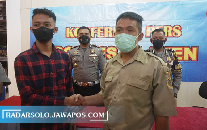 DAMAI: Pengemudi mobil ambulans dan mobil operasional dinkes yang saling berjabat tangan di Mapolres Klaten. (ANGGA PURENDA/RADAR KLATEN)
