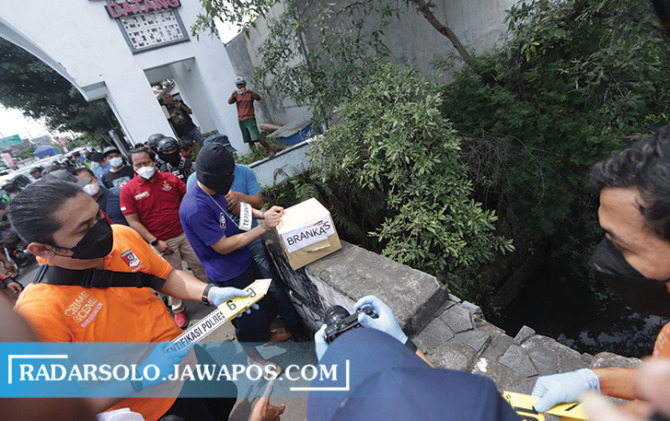SADIS: RS melakukan adegan rekonstruksi membuang brankas ke sungai usai menghabisi rekannya di Joyontakan, Serengan, Selasa (30/11). (M. IHSAN/RADAR SOLO)