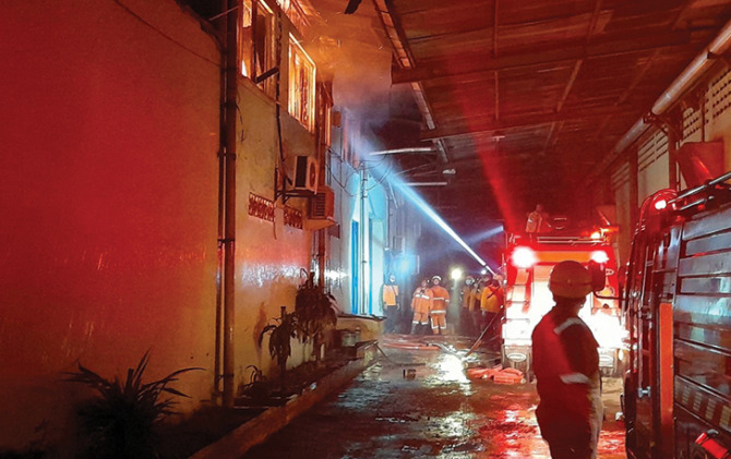 PROSES PENDINGINAN: Sejumlah aparat pemadam kebakaran dan jajaran terkait tengah melakukan proses pendinginan terhadap gudang pabrik kain tenun di Jaten yang terbakar. (RUDI HARTONO/RADAR SOLO)