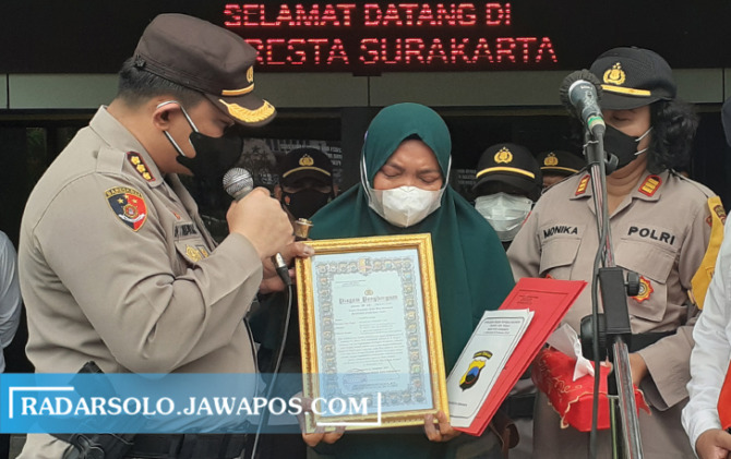 APRESIASI: Kapolresta Surakarta Kombes Pol Ade Safri Simanjuntak memberi penghargaan kepada korban yang diterima sang istri Senin (22/11). (A. CHRISTIAN /RADAR SOLO)