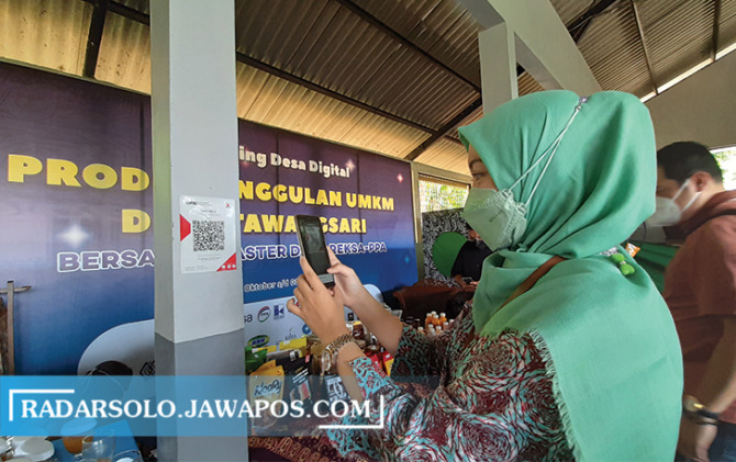 DIGITAL: Pembayaran cashless dengan scan barcode QRIS di bazar dan pelatihan pasar digital Desa Tawangsari, Teras, Boyolali. (RAGIL LISTIYO/RADAR SOLO)