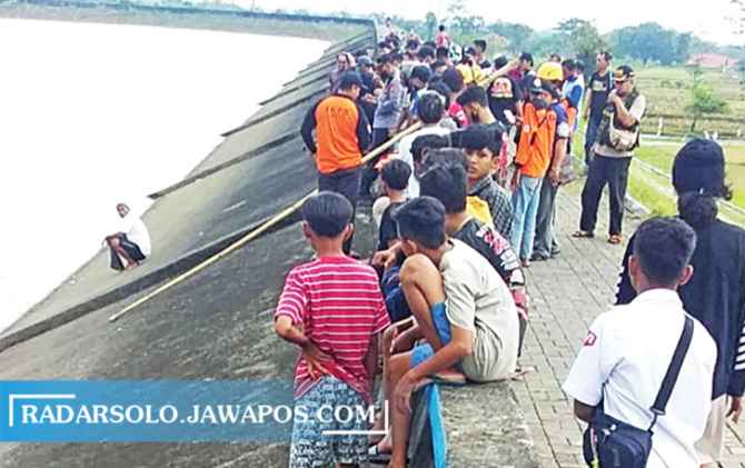 HARUS HATI-HATI: Warga melihat upaya pencarian korban tenggelam di Waduk Botok, Selasa (9/11).  (AHMAD KHAIRUDIN/RADAR SOLO)