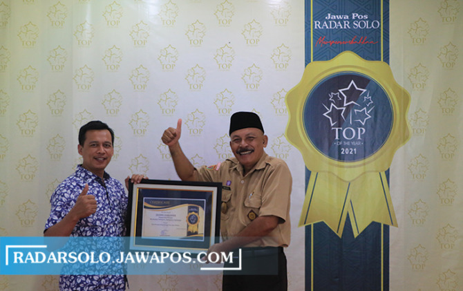 TOTAL MENGABDI: Kepala Desa Pranan, Kecamatan Polokarto, Kabupaten Sukoharjo menerima penghargaan Top of The Year 2021 dari General Manager Radar Solo Andi Aris. (  ARIEF BUDIMAN/RADAR SOLO)