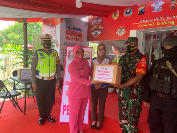 PERHATIAN: Ketua Bhayangkari Cabang Wonogiri Nadia Dydit Dwi Susanto beri tali asih kepada personel di Pos Terpadu 02 Selogiri, Minggu (26/12/2021).