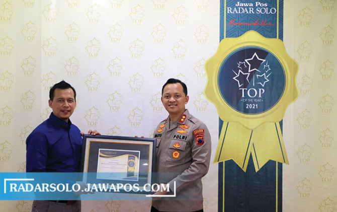 KETERBUKAAN INFORMASI: Kapolres Sukoharjo AKBP Wahyu Nugroho Setyawan menerima penghargaan Top Of The Year dari General Manager Radar Solo Andi Aris, kemarin. (ARIEF BUDIMAN/RADAR SOLO)