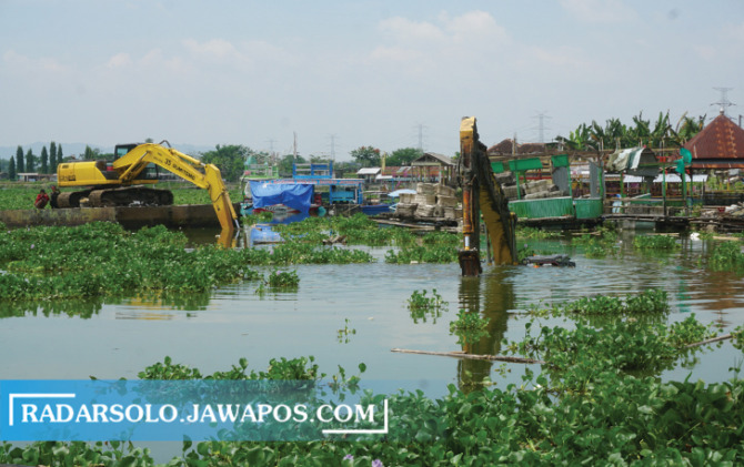 Proses evakuasi terhadap ekskavator yang tenggelam di Rowo Jombor, Desa Krakitan, Kecamatan Bayat, Rabu (08/12). Proses evakuasi ini  dengan ditarik unit ekskavator lain ke tepian. (ANGGA PURENDA/RADAR SOLO)