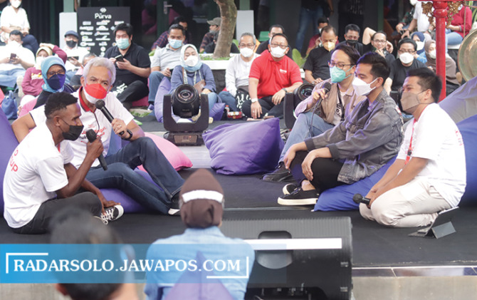 INTERAKSI: Gubernur Jawa Tengah Ganjar Pranowo berinteraksi dengan Daniel Sedik asal Papua yang mengikuti ajang booth camp di Hetero Space Solo, Minggu (19/12). (M. IHSAN/RADAR SOLO)
