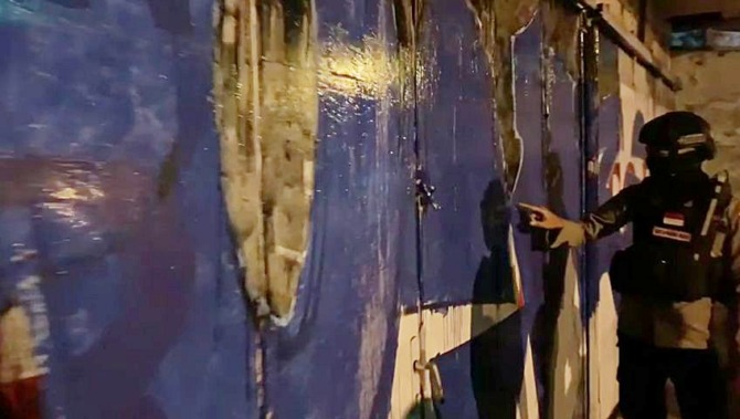 RUSAK KEINDAHAN KOTA: Tim Sparta Polresta Surakarta tunjukkan pintu bangunan bekas toko di Jalan A Yani yang jadi sasaran aksi coret-coret, Kamis (20/1) dini hari. (ISTIMEWA)