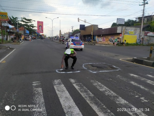 MEMBAHAYAKAN: Anggota Satlantas Polres Sukoharjo menandai lubang jalan di sejumlah lokasi belum lama ini.  (ISTIMEWA)