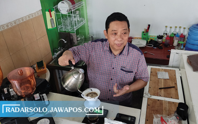 ENJOY: Mantan Wakil Bupati Wonogiri Edy Santosa menyeduk kopi di kedainya yang diberi nama Ngrembaka, kemarin (14/1). (IWAN ADI LUHUNG/RADAR SOLO)