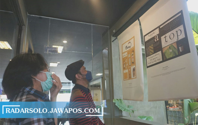 MENGAMATI: Pengunjung menikmati karya yang dipamerkan di ajang Nyantel Exhibition 2022 di Suaka Coffee, kemarin. (SEPTIAN REFVINDA/RADAR SOLO)