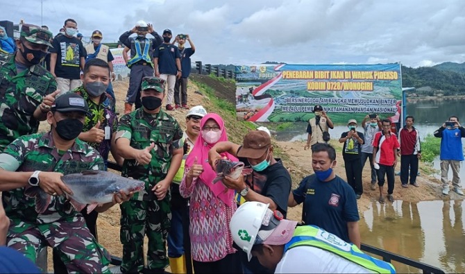JAGA EKOSISTEM: Jajaran Kodim 0728/Wonogiri bersama pihak terkait lainnya menebarkan benih ikan di Waduk Pidekso, Jumat (21/1). IWAN ADI LUHUNG/RADAR SOLO