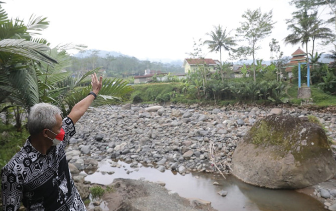 Gubernur Jateng Ganjar Pranowo saat melihat kondisi jembatan penghubung Desa Jebenplampitan, Kecamatan Sukoharjo, Kabupaten Wonosobo dengan Desa Larangan, Kecamatan Pagentan, Kabupaten Banjarnegara yang hilang diterjang banjir, Rabu (19/1).