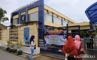 IUSTRASI: Warga membaca pengumuman tentang penerapan tes psikologi dalam pengurusan SIM di kantor Satpas Satlantas Polresta Surakarta. (DAMIANUS BRAM/RADAR SOLO)