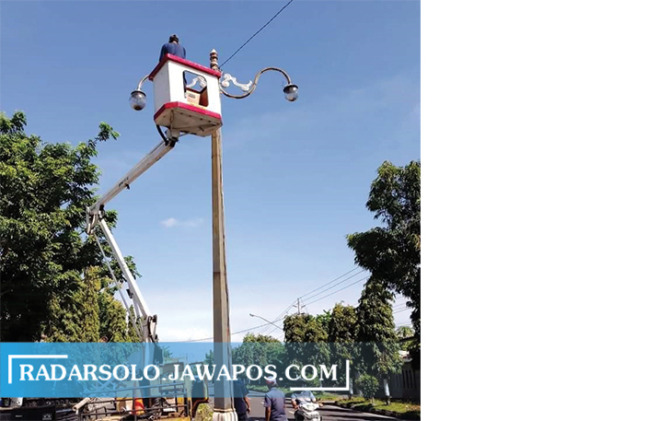 PERAWATAN RUTIN: Petugas memperbaiki kamera pemantau di simpang The Park Solobaru. (ISTIMEWA)