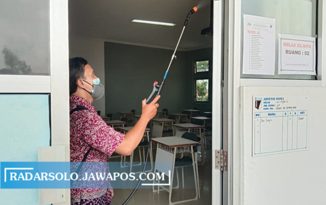 Penyemprotan disinfektan di ruang kelas SMA Warga Solo. (GERSON SETYO/RADAR SOLO)