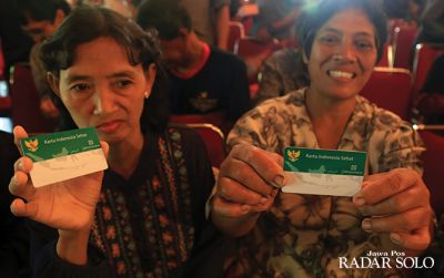 Warga menerima kartu JKN KIS yang dibagikan di balai kota, beberapa waktu lalu