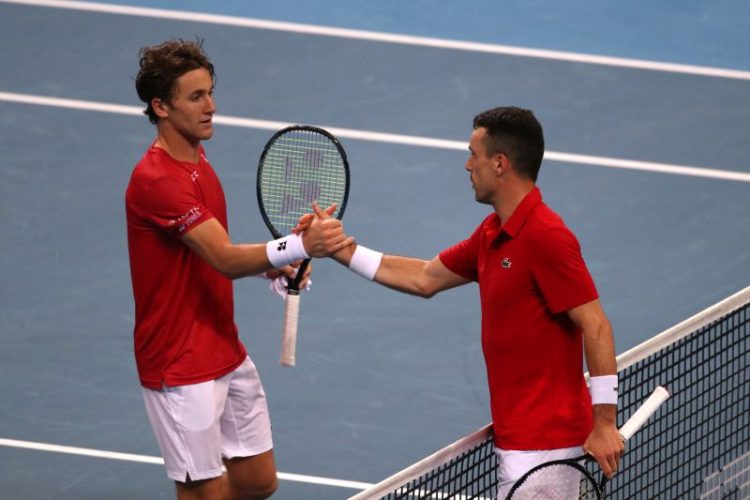 Petenis Spanyol Roberto Bautista Agut (kanan) berjabat tangan dengan Casper Ruud dari Norwegia setelah memenangi pertandingan penyisihan grup ATP Cup di Sydney Olympic Park, Sydney, Australia,