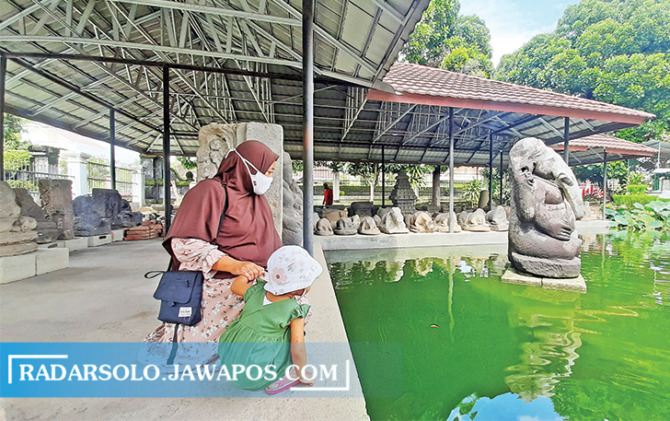 SARANA EDUKASI: Pengunjung melihat kolam ikan di samping rumah arca Taman Kota Boyolali. Pengelola tidak mengenakan biaya masuk. (RAGIL LISTIYO/RADAR SOLO)
