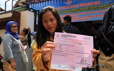 Warga menunjukkan kertas tanda lulus ujian psikologi pengurusan SIM.