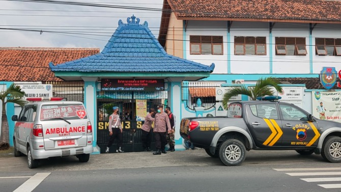 TRACING: Kepolisian berjaga di SMPN 3 Sawit saat digelar tes swab masal di sekolah setempat, kemarin. (RAGIL LISTIYO/RADAR SOLO)