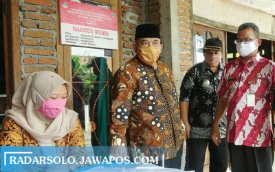 Bupati Sukoharjo Wardoyo Wijaya (berdiri paling kiri) saat meninjau penyaluran bantuan sosial, beberapa waktu lalu. (IWAN KAWUL/RADAR SOLO)