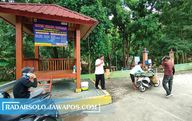 TERBUKA: Pengelola objek wisata Bayanan pasang spanduk berisi tarif wisata. (AHMAD KHAIRUDIN/RADAR SOLO)