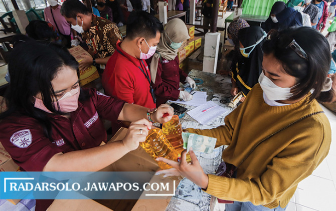 OPERASI PASAR: Warga Mojosongo berbondong-bondong antre mendapat 2 liter minyak goreng dengan harga murah kemarin (23/2). (M. IHSAN/RADAR SOLO)
